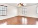 Bright bedroom with wood-look floors, a ceiling fan, and multiple windows at 2790 S Alpine Dr, Gilbert, AZ 85295