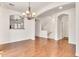 Dining room features hardwood floors, designer chandelier, and view to staircase at 2790 S Alpine Dr, Gilbert, AZ 85295