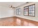Spacious living room with wood-look floors, ceiling fan, and large windows at 2790 S Alpine Dr, Gilbert, AZ 85295