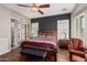 Comfortable bedroom with wood flooring, wood ceiling fan, and a relaxing accent chair at 28798 N 127Th Ave, Peoria, AZ 85383