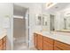 Bright bathroom featuring a neutral-toned vanity, framed mirror and a shower with glass block window at 3441 E Melody Dr, Phoenix, AZ 85042