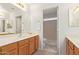 Bright bathroom featuring a neutral-toned vanity, framed mirror and a shower with glass block window at 3441 E Melody Dr, Phoenix, AZ 85042