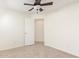 Neutral bedroom with ceiling fan, carpeted floor, and a door leading to another room at 3441 E Melody Dr, Phoenix, AZ 85042