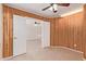 Charming den with wood-paneled walls, neutral carpet, and double doors leading to another room at 3441 E Melody Dr, Phoenix, AZ 85042