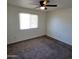 This cozy bedroom features neutral carpeting, a ceiling fan, and a window for natural light at 3645 N 69Th Ave # 99, Phoenix, AZ 85033