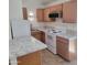 An updated kitchen with white appliances and light wood cabinets at 3645 N 69Th Ave # 99, Phoenix, AZ 85033