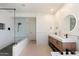 Modern bathroom with double vanity, standalone shower with glass door, and stylish round mirrors at 4202 E Catalina Dr, Phoenix, AZ 85018