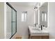 Modern bathroom with double vanity, standalone shower with glass door, and stylish lighting at 4202 E Catalina Dr, Phoenix, AZ 85018