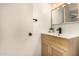 Well-lit bathroom featuring a modern vanity with a black faucet and stylish woven wood cabinet at 461 W Holmes Ave # 323, Mesa, AZ 85210