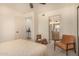 Serene bedroom featuring a neutral palette, inviting chair and view to the ensuite bath at 461 W Holmes Ave # 323, Mesa, AZ 85210