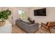 Cozy living room with hardwood floors, a large window, and a comfortable gray sofa at 461 W Holmes Ave # 323, Mesa, AZ 85210