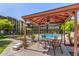 Relaxing poolside canopy with ceiling fan, table and chairs, offering a cool retreat with community pool views at 461 W Holmes Ave # 323, Mesa, AZ 85210
