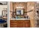 Bathroom vanity with granite countertops, warm tile accents, decorative mirror, and ample storage space at 4627 W Laurie Ln, Glendale, AZ 85302