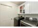 Modern laundry room with white cabinets and gray front load washer and dryer at 4627 W Laurie Ln, Glendale, AZ 85302