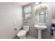 Practical powder room featuring a pedestal sink, toilet, and a window at 509 S 111Th Dr, Avondale, AZ 85323