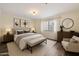 Cozy bedroom featuring a large bed, a bench, neutral colors, and wood-look floors at 5104 N 32Nd St # 114, Phoenix, AZ 85018