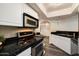 Well-lit kitchen showcasing stainless steel appliances and sleek black granite countertops at 5104 N 32Nd St # 114, Phoenix, AZ 85018