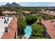 Aerial view of a community pool with palm trees and red tiled roofs at 5104 N 32Nd St # 114, Phoenix, AZ 85018
