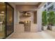 Outdoor kitchen featuring a built-in grill with a herringbone backsplash, a stainless steel hood, and a pizza oven at 5250 E Deer Valley Dr # 146, Phoenix, AZ 85054