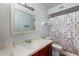 Bright bathroom featuring a large vanity, mirror, and shower with a geometric pattern curtain at 5432 W Sunnyside Dr, Glendale, AZ 85304