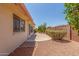 Backyard with brick accents, gravel, patio, and partial landscaping at 7910 E Navarro Ave, Mesa, AZ 85209