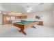 Open floor plan with a pool table and kitchen in background offers entertainment and culinary space at 7910 E Navarro Ave, Mesa, AZ 85209