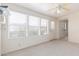 Bright room featuring neutral carpet, a ceiling fan, and large windows at 7910 E Navarro Ave, Mesa, AZ 85209