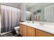 Bathroom with double sinks, wooden cabinets, and a shower with curtain at 861 E Indian Wells Pl, Chandler, AZ 85249