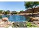 Peaceful community pond with rock features, landscaping, and views of nearby houses at 861 E Indian Wells Pl, Chandler, AZ 85249