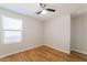 Cozy bedroom featuring hardwood floors, a ceiling fan, and large window at 8744 W Superior Ave, Tolleson, AZ 85353