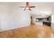 Open-concept living space with hardwood floors, a ceiling fan, and views into the kitchen at 8744 W Superior Ave, Tolleson, AZ 85353