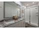 Bathroom with double sinks, granite countertops, framed mirror, and walk-in shower with subway tile at 9835 E Wavelength Ave, Mesa, AZ 85212