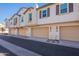Charming townhome exterior featuring a row of garages with updated lighting at 9835 E Wavelength Ave, Mesa, AZ 85212