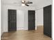 Large bedroom with ceiling fan, three doors and wood-look flooring at 10046 E Posada Ave, Mesa, AZ 85212