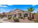Charming single-story home with desert landscaping, a two-car garage, and a well-maintained lawn at 10046 E Posada Ave, Mesa, AZ 85212