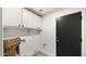 Bright laundry room with black door, upper cabinets, and luxury vinyl plank flooring at 10046 E Posada Ave, Mesa, AZ 85212
