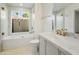 Bright bathroom featuring a tub shower combination with a glass enclosure and vanity with marble countertop at 10300 N 48Th Pl, Paradise Valley, AZ 85253