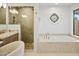 Bathroom featuring a shower, a tub, a decorative window, and wood cabinets at 10300 N 48Th Pl, Paradise Valley, AZ 85253