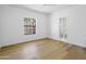 Minimalist bedroom with light hardwood flooring, a window looking outdoors, and a view into the bathroom at 10300 N 48Th Pl, Paradise Valley, AZ 85253