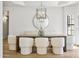 A stylish dining area has wood table, modern chairs, a unique light fixture, and a round mirror at 10300 N 48Th Pl, Paradise Valley, AZ 85253