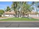 Charming home with mature trees, lush lawn, and a covered entryway, creating a welcoming curb appeal at 10300 N 48Th Pl, Paradise Valley, AZ 85253