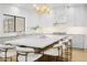 Modern kitchen has marble countertops, an island with seating, and a stylish gold light fixture at 10300 N 48Th Pl, Paradise Valley, AZ 85253