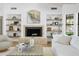 An inviting living room includes a brick fireplace, built in shelves, and a comfortable white couch at 10300 N 48Th Pl, Paradise Valley, AZ 85253