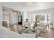 Bright living room featuring wood floors, white furniture, and large windows providing natural light at 10300 N 48Th Pl, Paradise Valley, AZ 85253