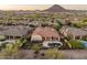 Expansive aerial view of a luxury home with a pool and putting green in a desert community at 12809 W Oyer Ln, Peoria, AZ 85383