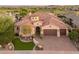 Aerial view of desert home with tile roof, three-car garage, putting green and lush desert landscaping at 12809 W Oyer Ln, Peoria, AZ 85383