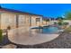 Panoramic backyard view showcasing a sparkling pool, outdoor kitchen, lush desert landscaping, and patio at 12809 W Oyer Ln, Peoria, AZ 85383