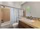 Cozy bathroom features a shower-tub combo with a floral shower curtain and a vanity with a mirror at 12809 W Oyer Ln, Peoria, AZ 85383
