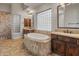 Bathroom featuring a soaking tub, dual sinks, and tiled flooring at 12809 W Oyer Ln, Peoria, AZ 85383