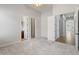 Carpeted bedroom with open doorways to ensuite bathroom and hallway at 12809 W Oyer Ln, Peoria, AZ 85383